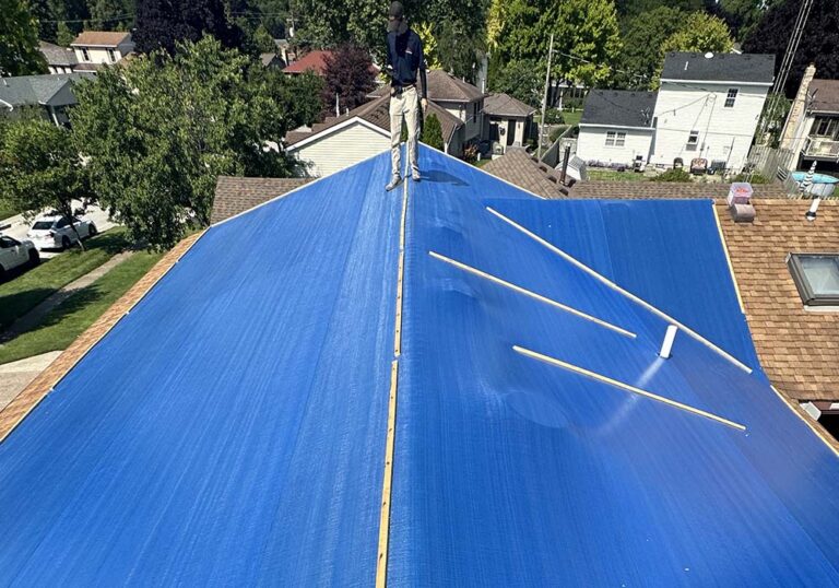 A blue tarp on the roof of a house.