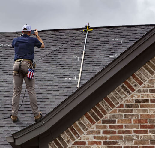 A man is working on the roof of a house.